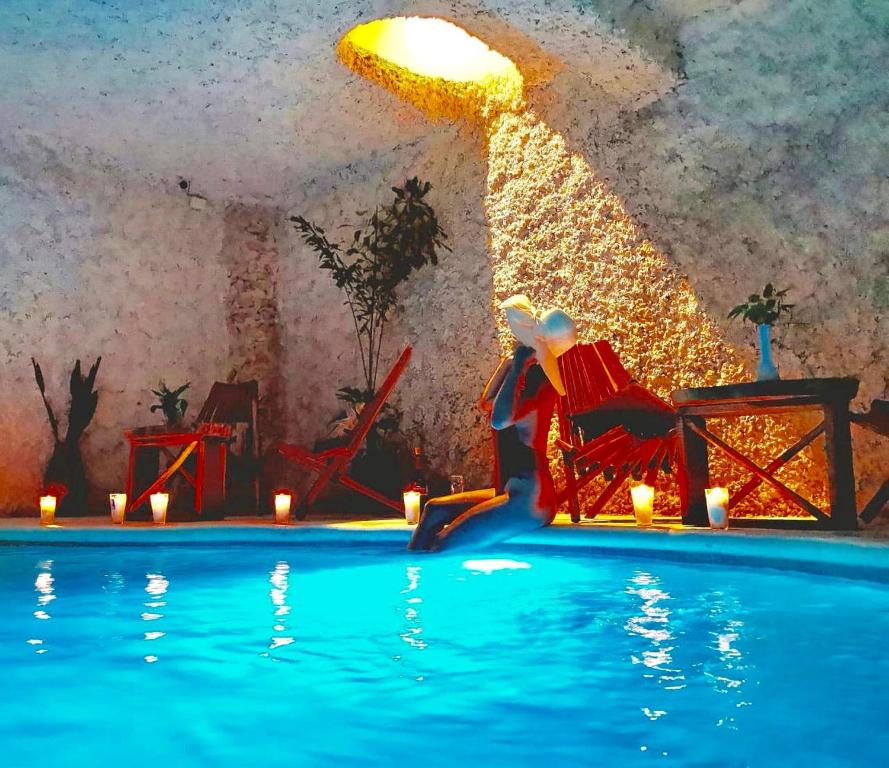 a person sitting in a chair next to a swimming pool at Mayan Majesty Boutique Hotel in Valladolid