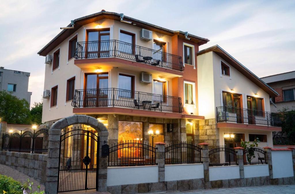 un gran edificio blanco con balcones. en Family Hotel Preslav, en Veliki Preslav