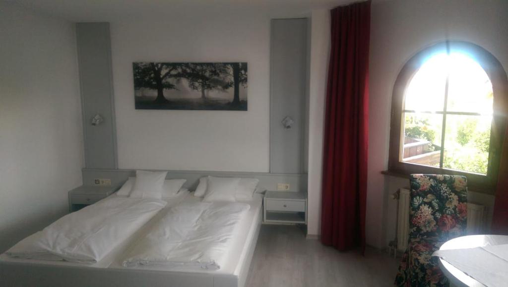 a bedroom with a white bed and a window at Leiselheimer Hof in Sasbach am Kaiserstuhl