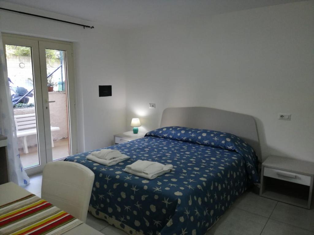 - une chambre avec un lit et une couette bleue dans l'établissement Monolocale Tirreno studio seafront, à Formia