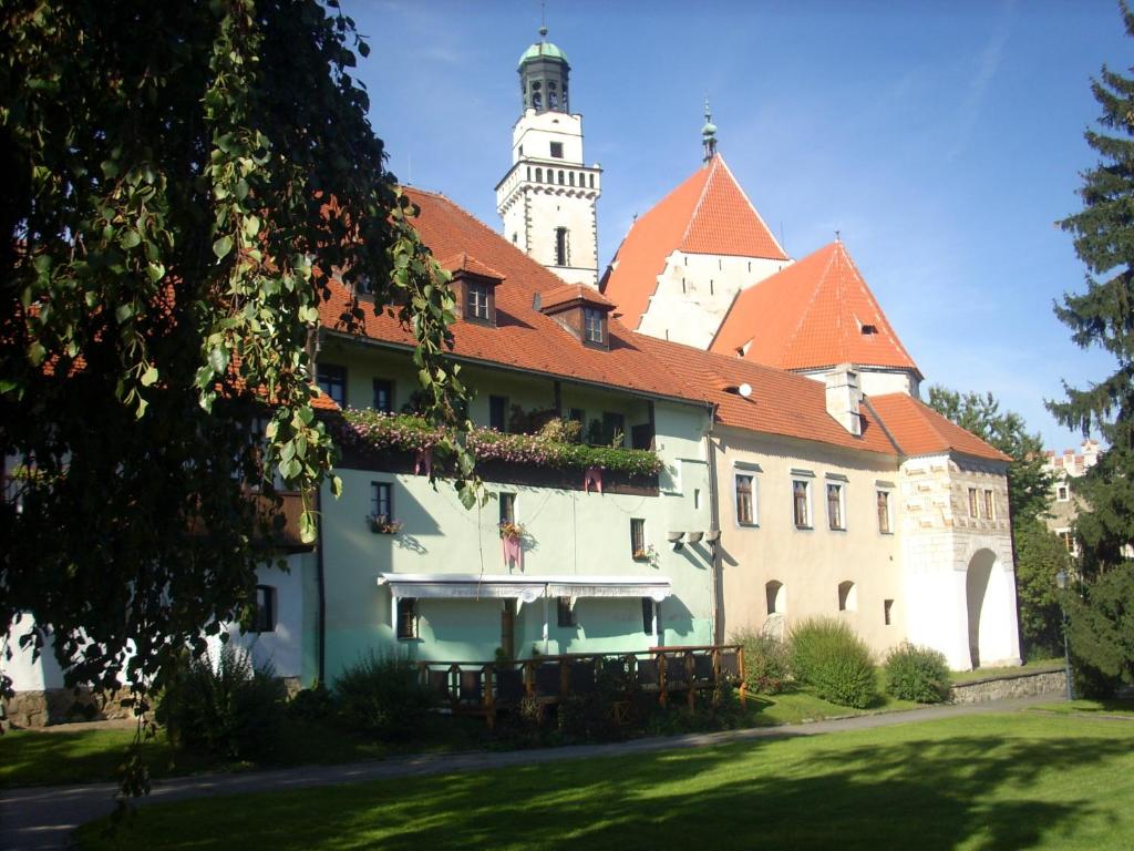 ein Gebäude mit einem Uhrturm im Hintergrund in der Unterkunft Hotel Parkán in Prachatice