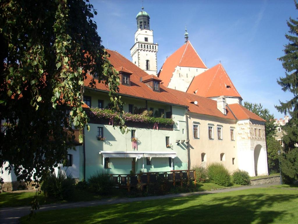 a building with a clock tower in the background at Hotel Parkán in Prachatice