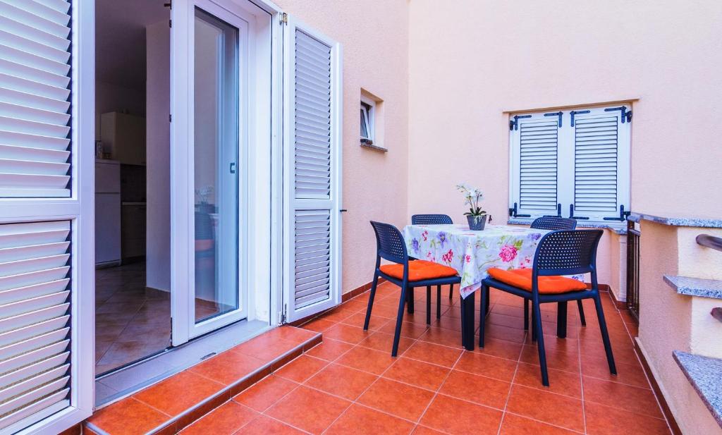 a patio with a table and chairs on a balcony at Apartments Nicole in Pula