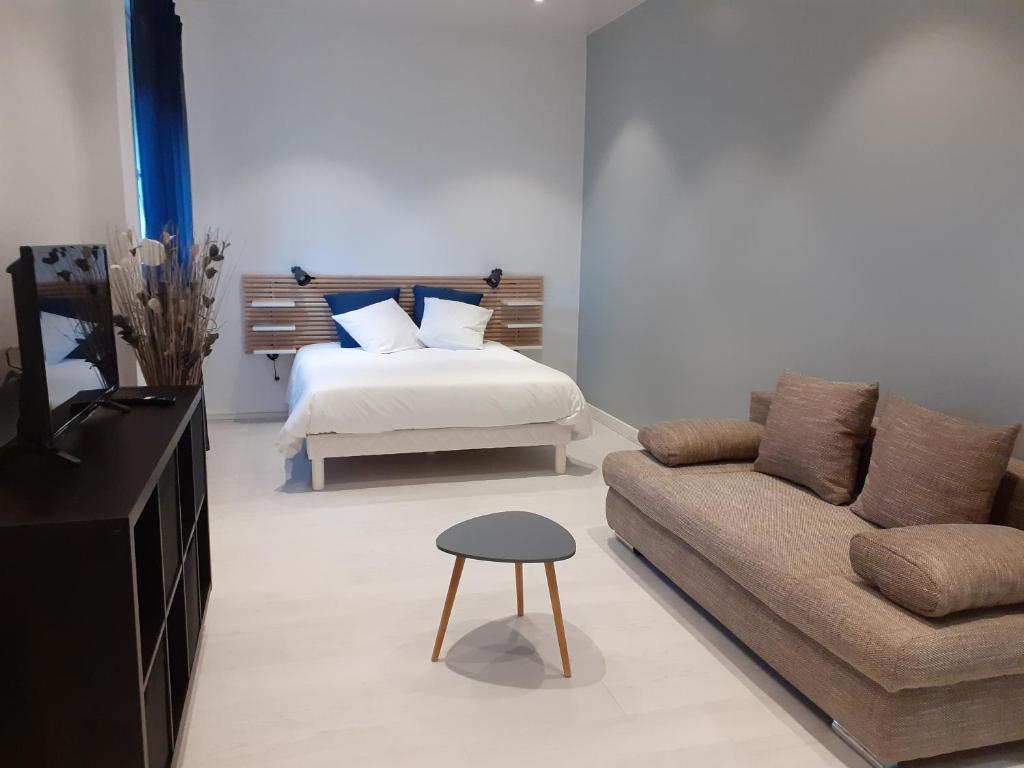 ein Wohnzimmer mit einem Bett und einem Sofa in der Unterkunft La belle étoile in Varennes-en-Argonne