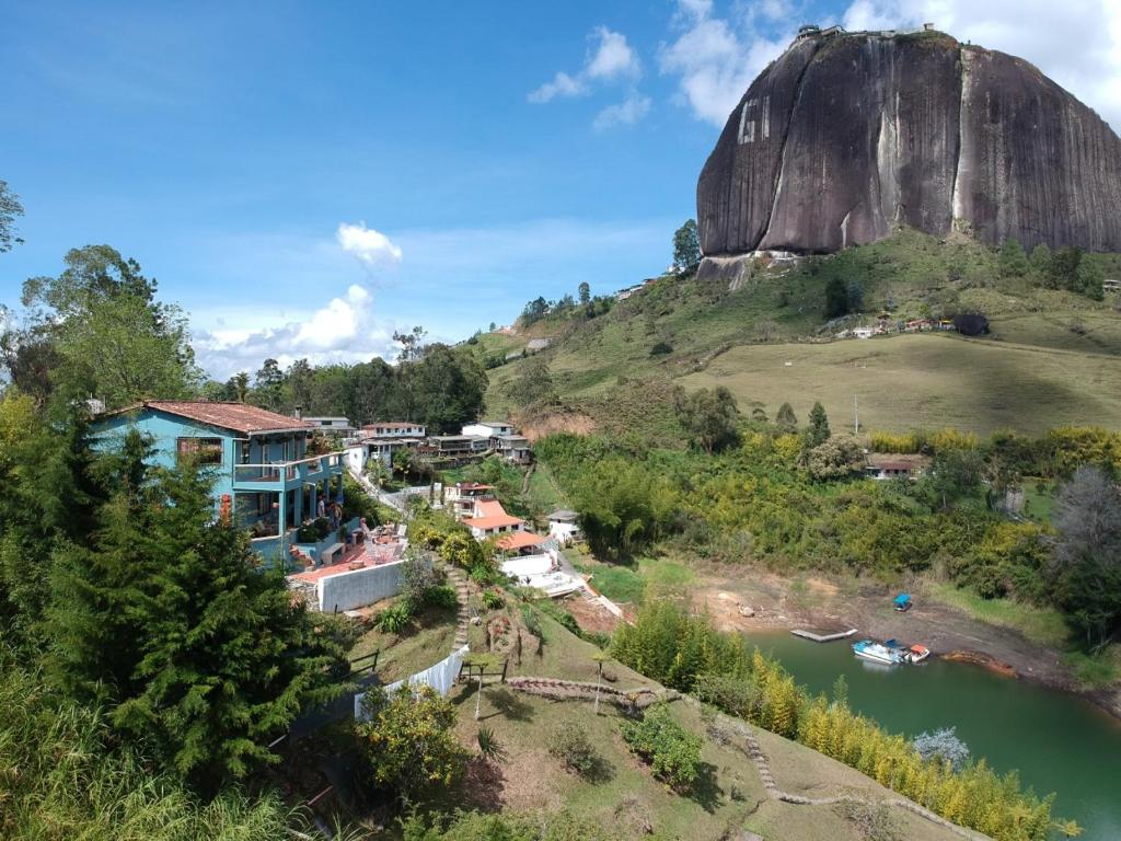 a house on a hill next to a river at Casa Galeria Guatape in Guatapé