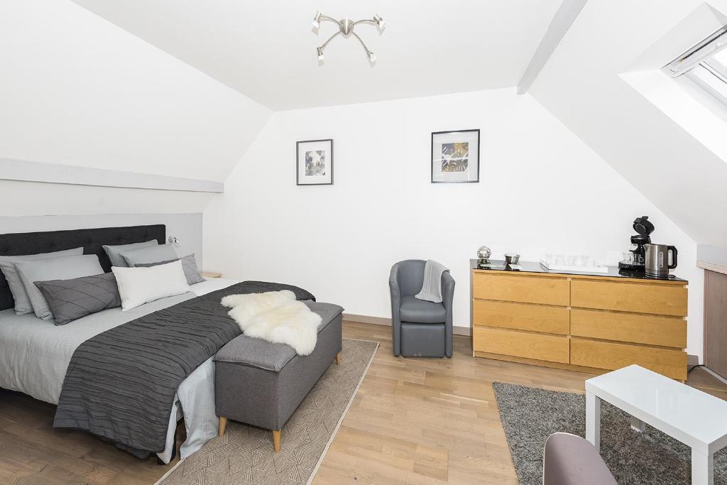 a bedroom with a bed and a chair and a dresser at Chambres d'hôtes près de Disney in Fontenay-Trésigny