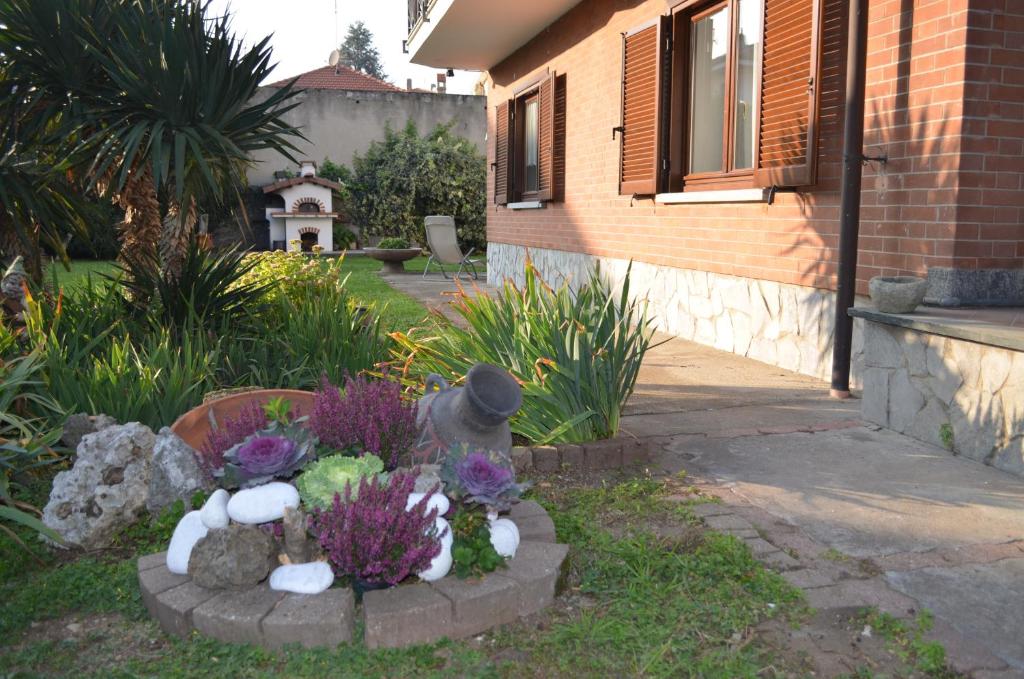 a garden with flowers and rocks in a yard at la casa di sotto in Alpignano