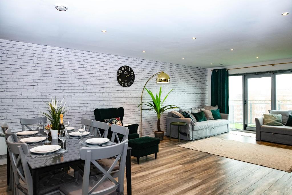 a dining room and living room with a brick wall at Paramount Views in Swindon