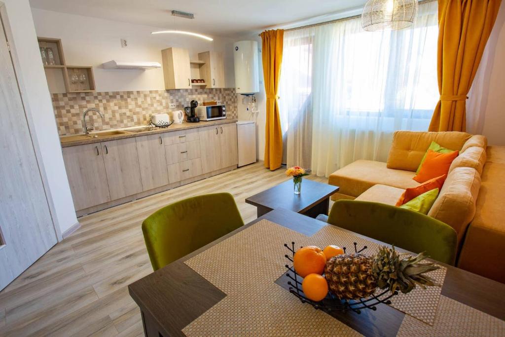 una cocina y una sala de estar con una mesa con fruta. en Apartamente Primaverii 2, en Buşteni