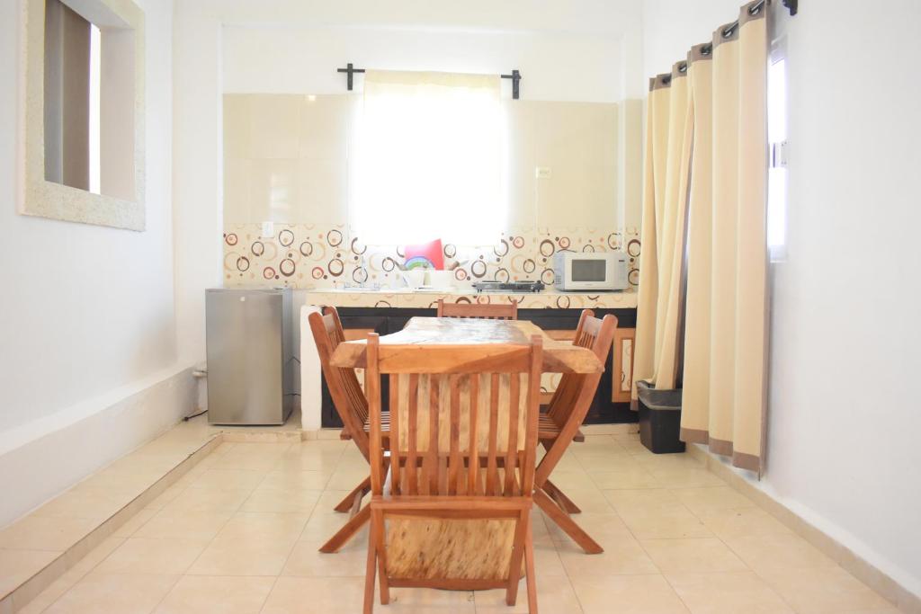 a dining room with a table and chairs and a kitchen at Hotel Caracol Isla Mujeres in Isla Mujeres