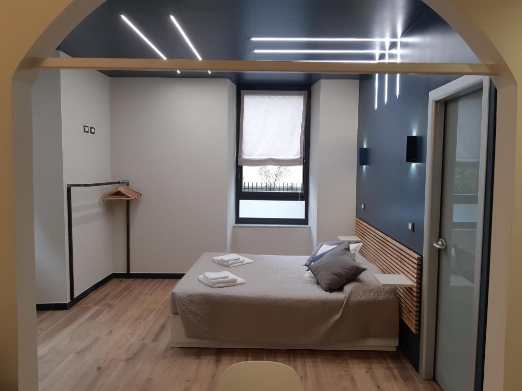 una camera con un letto in una stanza con una finestra di Il Giardino di Elettra - FreeParking a Genova
