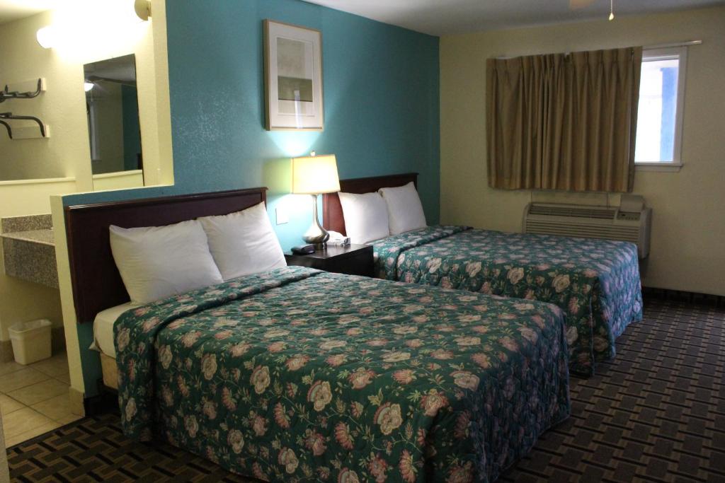 Habitación de hotel con 2 camas y ventana en American Inn Port O'Connor, en Port O'Connor