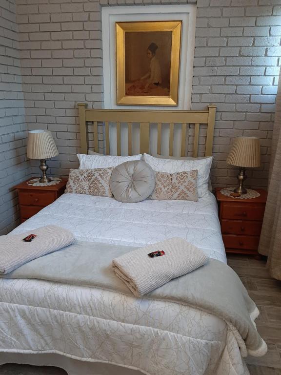 a bedroom with a white bed with two towels on it at Mrs Catherines Selfcatering Apartment in George