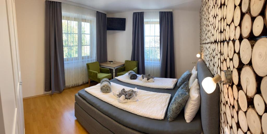 sala de estar con 2 camas y sofá en Gasthaus & Hotel Backhendlstation, en Enns