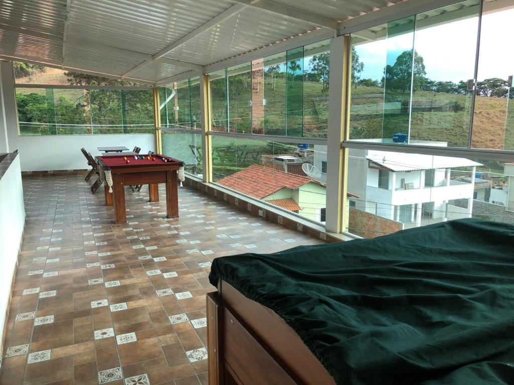een grote kamer met een pooltafel en ramen bij Pousada Dom Pedro in Caxambu