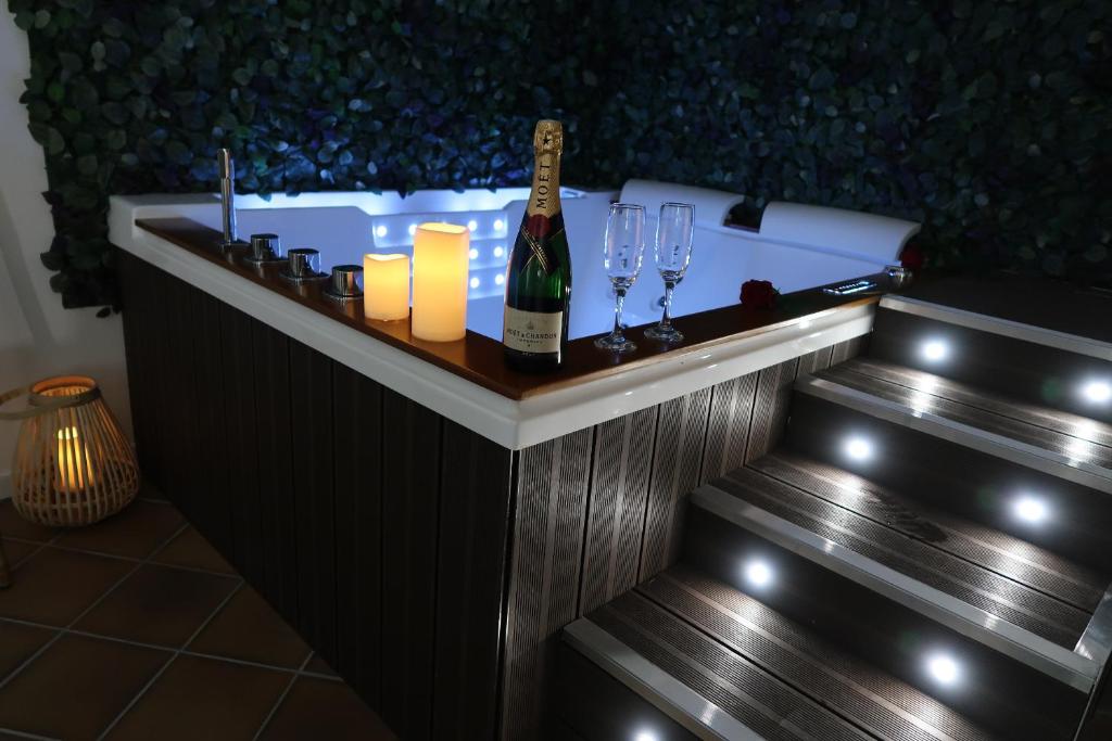 un bar con una botella de champán y copas de vino en La Suite, en Saint-Valéry-en-Caux