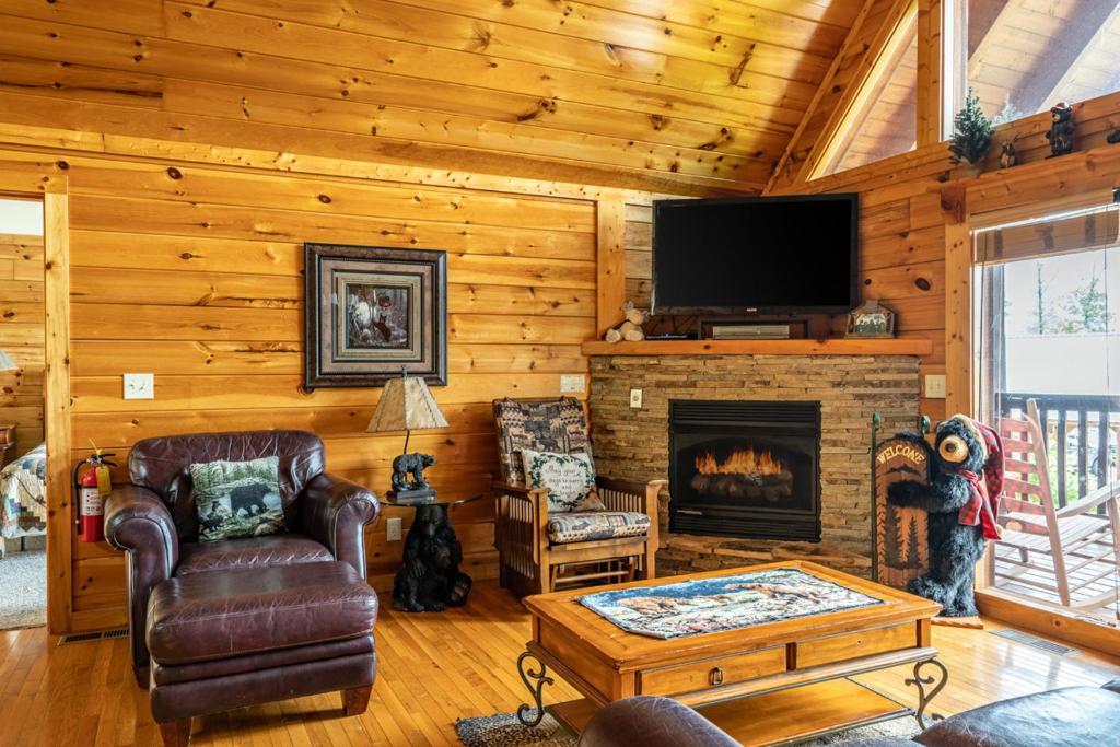 a living room with a fireplace and a flat screen tv at Closer to Home in Gatlinburg