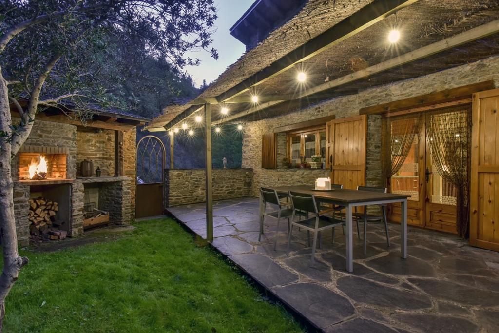 un patio al aire libre con mesa y chimenea en Cal Gineró, en Vall de Castellbò