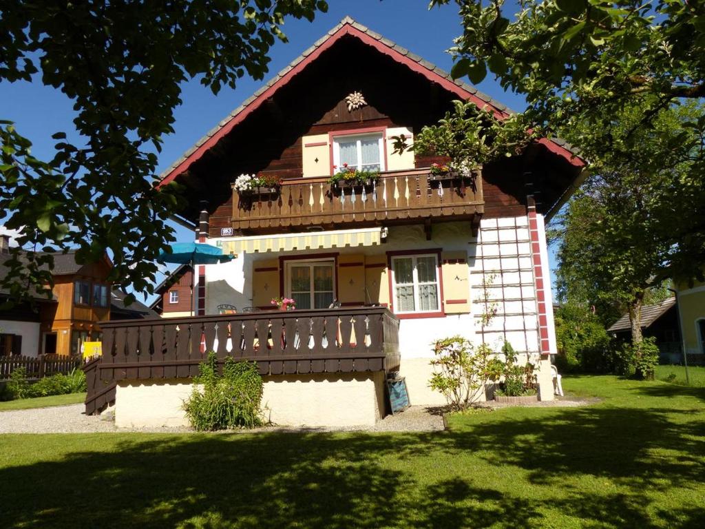 a house with a balcony and a wooden fence at Knusperhaus in Strobl