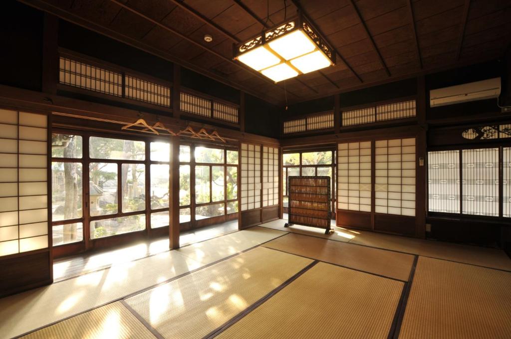 una habitación vacía con ventanas y alfombras en un edificio en Kanakuraen / Vacation STAY 5125 en Marugame