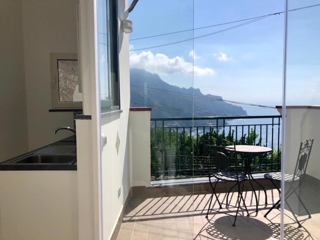 een balkon met een tafel en uitzicht op een berg bij Alleria in Ravello