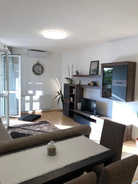 ein Wohnzimmer mit einem Sofa und einem Tisch in der Unterkunft Casa Blanca in Nyíregyháza