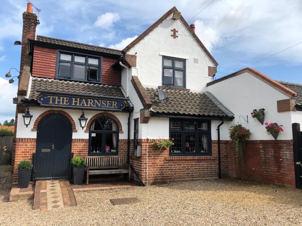 a white and red building with a black door at The Harnser in Stalham