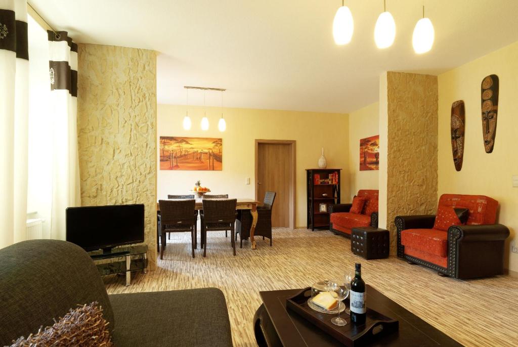 ein Wohnzimmer mit einem Sofa und einem Esszimmer in der Unterkunft Mosella Ferienwohnungen in Bernkastel-Kues
