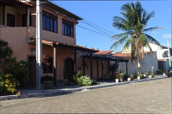 um edifício com uma palmeira em frente a uma rua em Pousada Ateliê Flat Residence em Cabo Frio