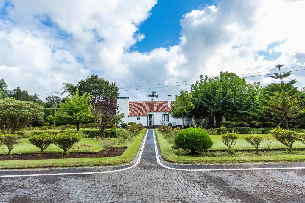 une route devant une maison blanche dans l'établissement Casa das Duas Ribeiras, à Furnas