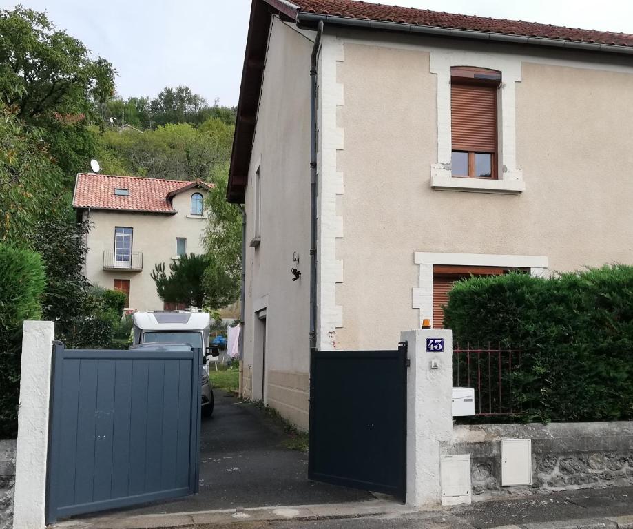 una casa con una puerta azul delante de ella en Gîte43, en Decazeville