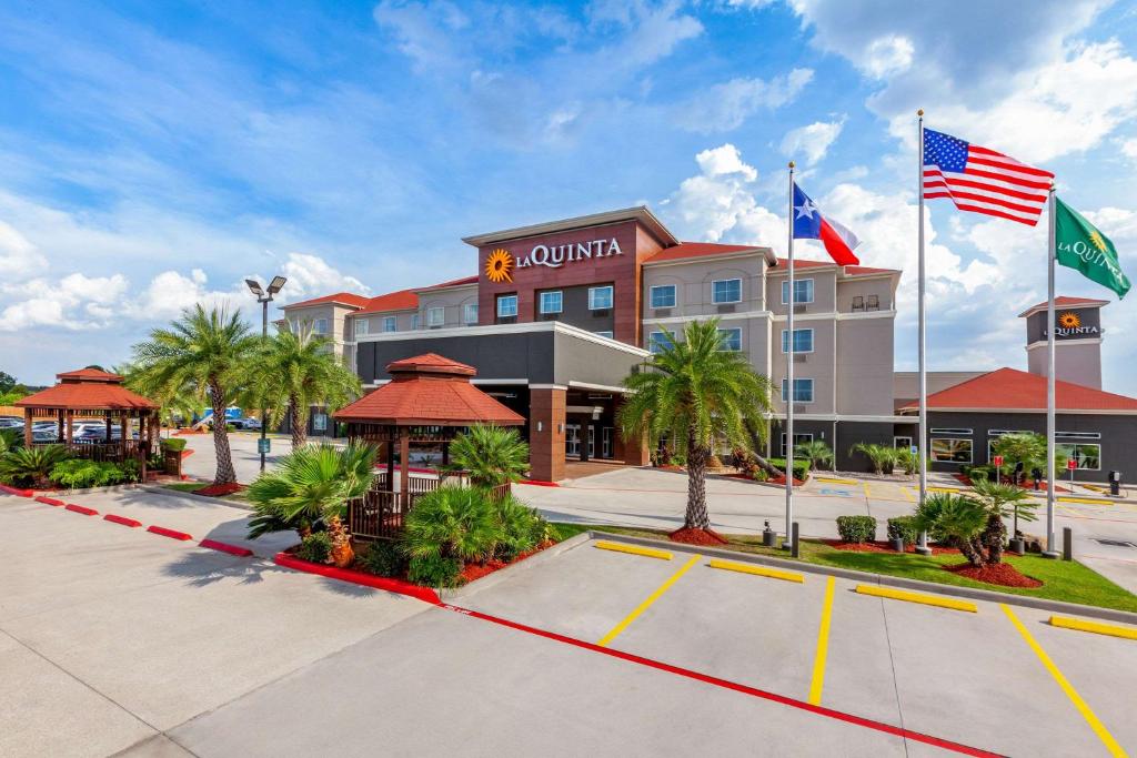 a hotel with flags in front of a building at La Quinta by Wyndham Houston Channelview in Houston