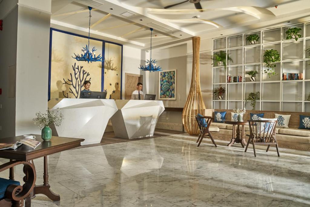a lobby of a hotel with a reception desk and chairs at Sofiana My Khe Hotel & Spa- Rooftop Pool Bar in Danang