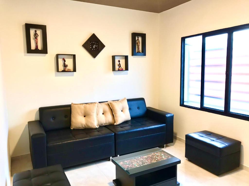 sala de estar con sofá negro y ventana en Casa Santa Isabel, en Santa Rosa de Cabal