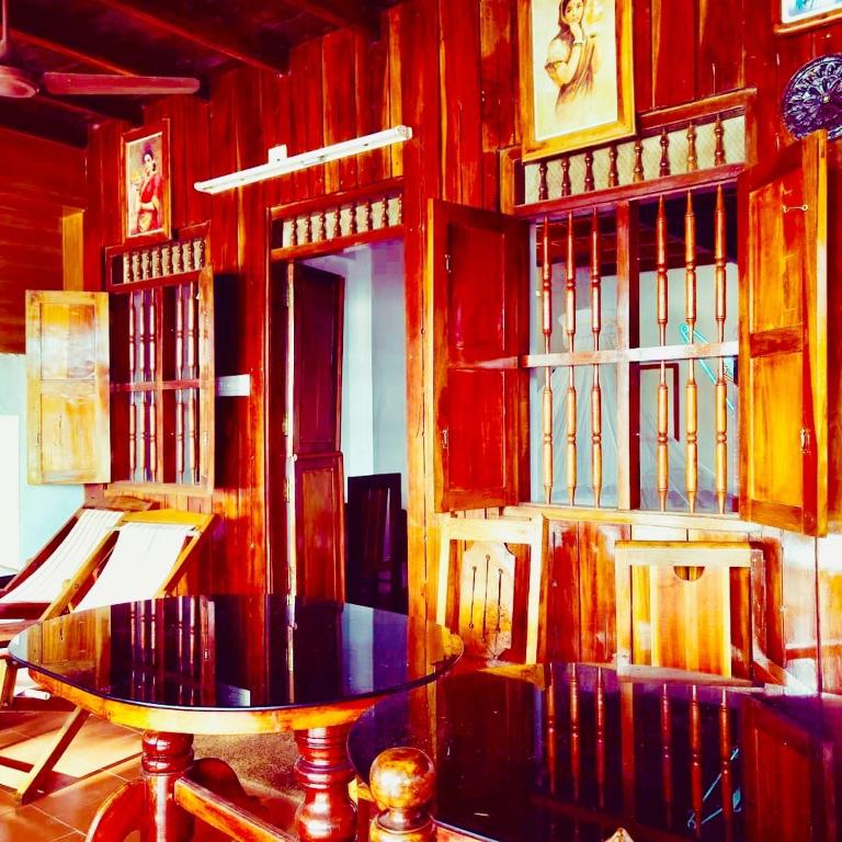 a wooden room with a table and a clock on a wall at Malayalam Lake Resort in Alleppey