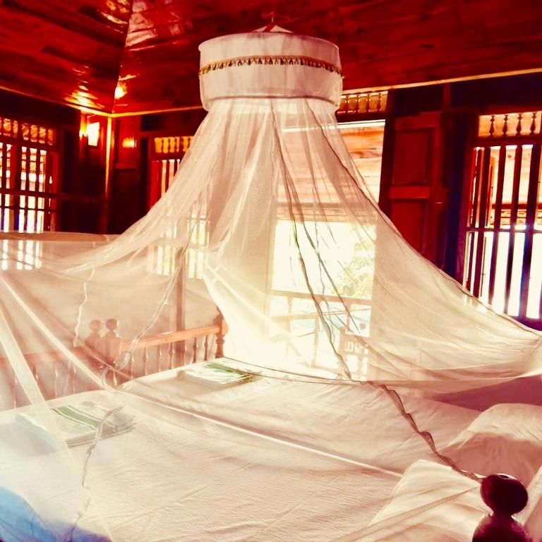 a white bed with a canopy in a room at Malayalam Lake Resort in Alleppey