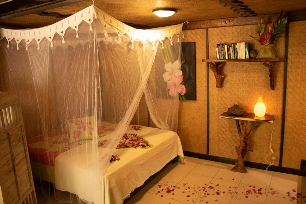 - une chambre avec un lit à baldaquin dans l'établissement Haere Mai I Te Fare, à Teavaro