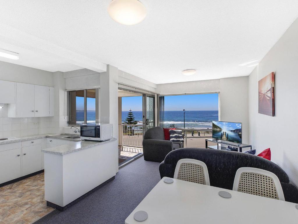 a kitchen and living room with a view of the ocean at Dolphin Court 6 in The Entrance
