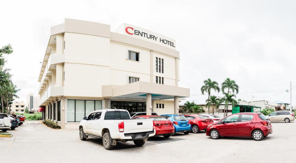 a parking lot in front of a car dealership at Century Hotel in Garapan