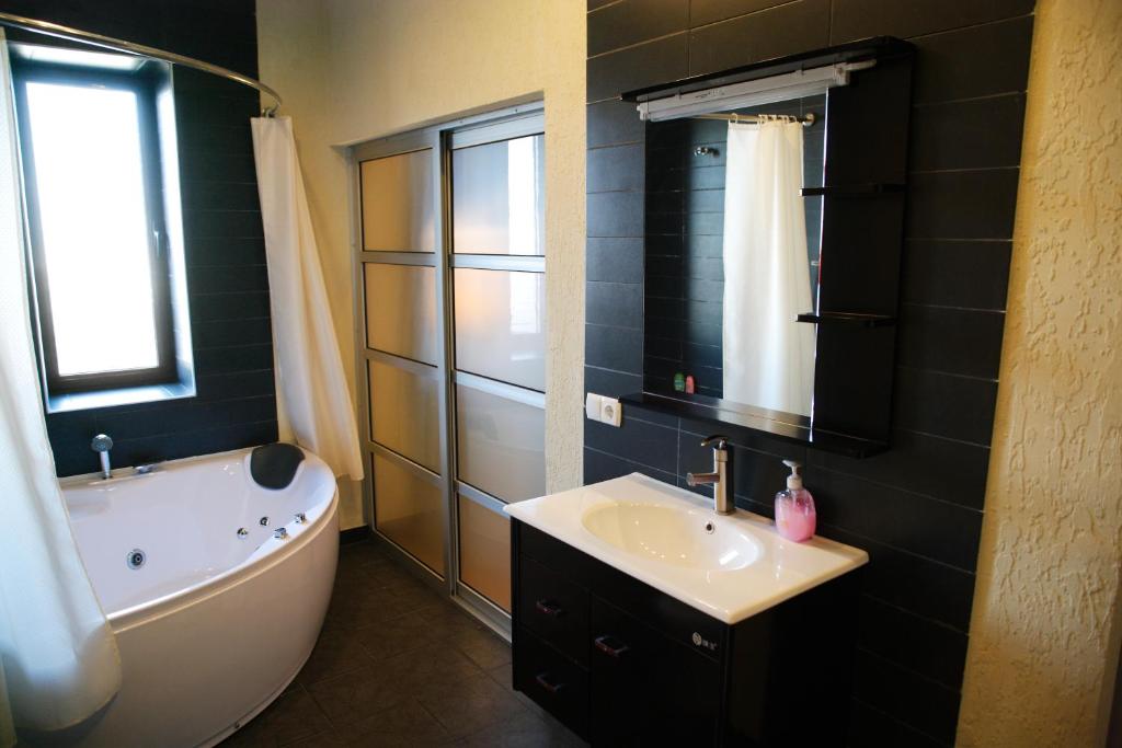 a bathroom with a tub and a sink and a bath tub at Tian-Shan Hotel in Bishkek