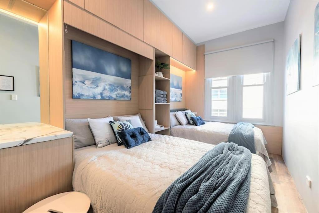 una camera con due letti e un grande dipinto sul muro di 2 Private Double Bed In Sydney CBD Near Train UTS DarlingHar&ICC&C hinatown - ROOM ONLY a Sydney