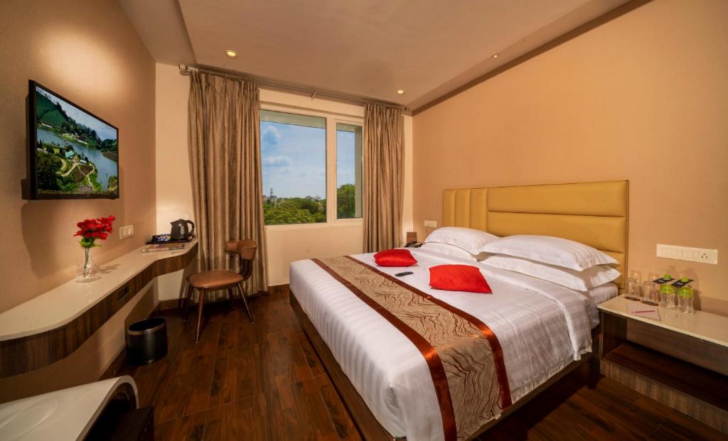 um quarto de hotel com uma cama grande e uma janela em CR Grande em Madurai