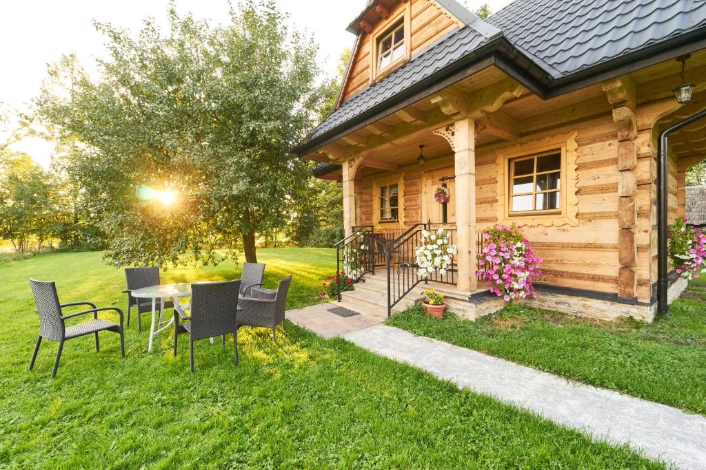 ホホウフにあるDomek nad Młynówkąの庭にテーブルと椅子が備わる木造家屋