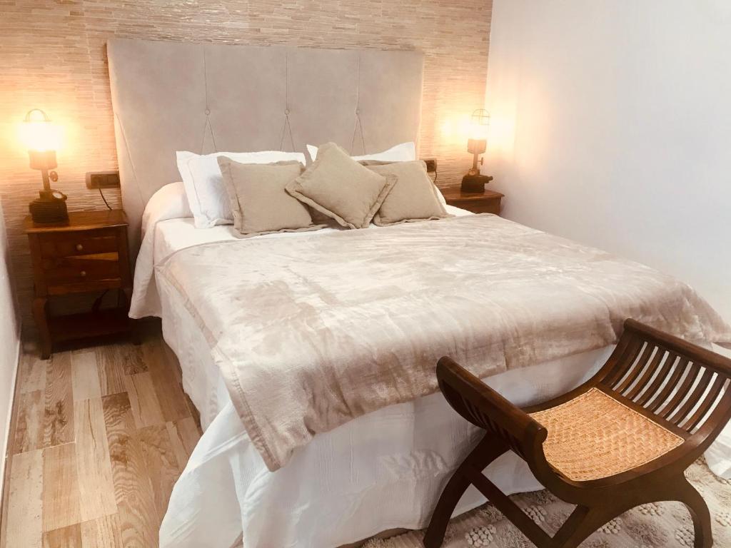 a bedroom with a large white bed with a chair at SUNSET IN LOFT in Playa Honda