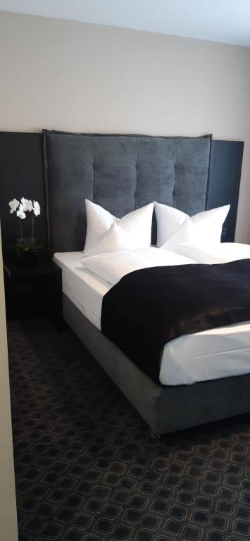 a bedroom with a large bed with white pillows at Remstal Hotel in Weinstadt