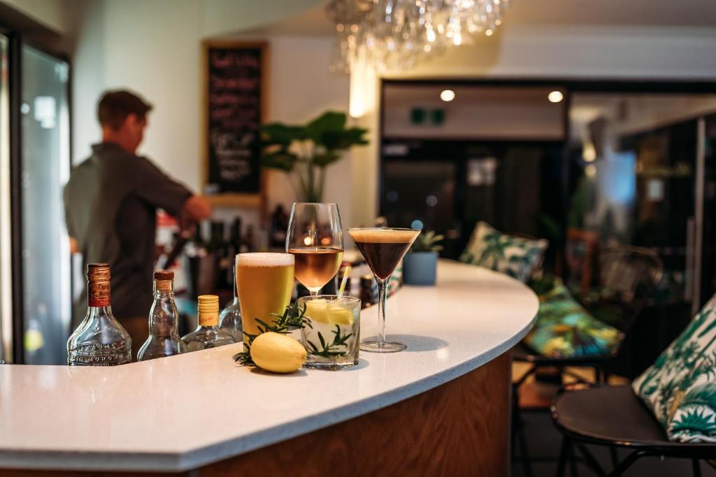 eine Bar mit Flaschen und Gläsern auf der Theke in der Unterkunft Kobbers Motor Inn in Dalby