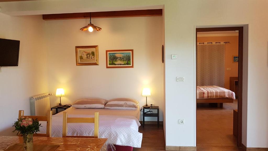 sypialnia z łóżkiem i pokój ze stołem w obiekcie Apartment Liznjan 1705 w mieście Ližnjan
