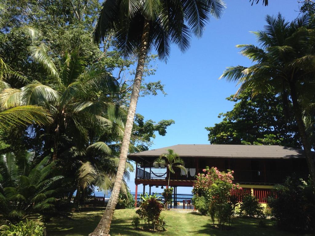 a resort with palm trees in front of a building at Finca El Regalo in Capurganá