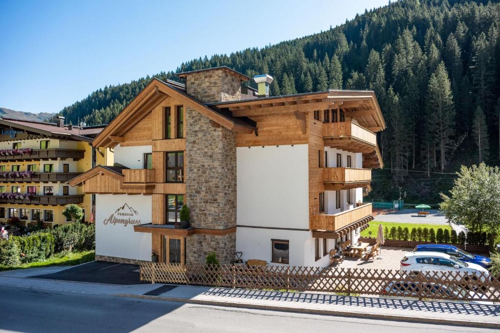 a building with a mountain in the background at Hotel Pension Alpengruß in Tux