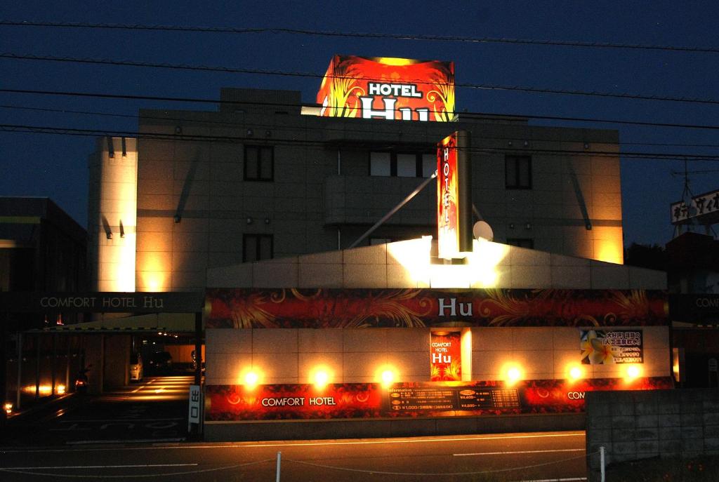 un hotel con un cartello sopra di esso di notte di Comfort Hotel Hu a Koshigaya